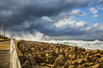 The storm in the Mediterranean Sea. Huge foaming waves beating against the shore. New Quay in the