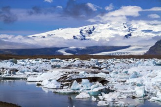 Clear and cold day in July. Arctic Circle. White and blue icebergs and ice floes reflected in the
