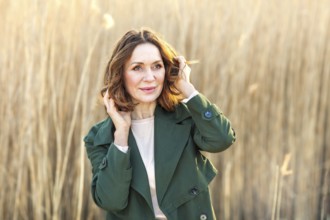 Portrait of a beautiful middle-aged woman posing at sunset