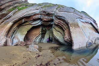 Picturesque huge cave on the beach. Low tide in the Atlantic. Flysch - unique landscape of