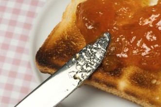 Spread jam on bread with knife