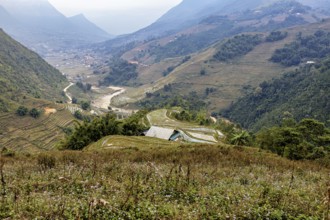An impressive landscape with green valleys, hills and a meandering river, farms in the rice paddies
