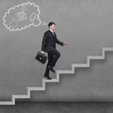 Image of confident businessman with briefcase walking upstairs