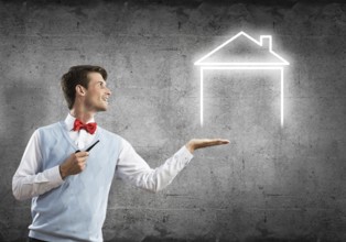 Confident and young businessman smoking pipe and drawn house on gray wall background