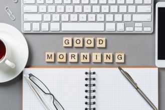 Good morning message with letters on wooden cubes. Still life of workspace with supplies. Flat lay
