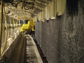 Conveyor belt in tunnel with yellow machine, Bochum, North Rhine-Westphalia, Germany