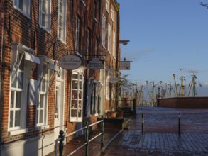 Old town street with traditional buildings, shops and view of the harbour in the winter sun,