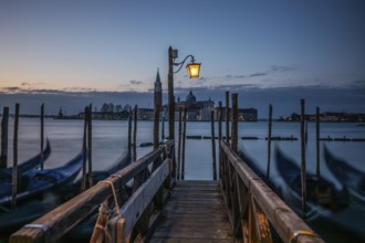 Morning atmosphere, Venetian gondolas with the church of San Giorgio Maggiore in the background,