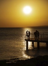 Silhouette of young couple enjoying beautiful sunset at the beach. Romantic moment human