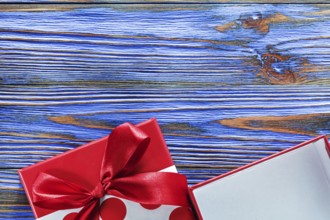 Red packed present box on vintage wooden board