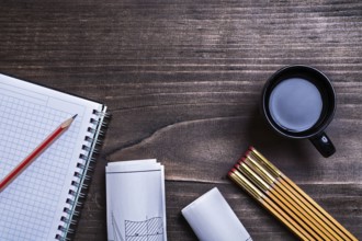 Notepad pencil construction drawings wooden meter and cup of coffee on wood board maintenance