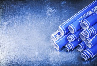 Blue rolled construction plans on metallic background copy space maintenance concept