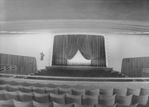 Cinema in the 1940s. An interior of a typical looking movie theatre with seats near the film screen