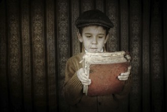Child with red vintage book. Vintage clothes and hat