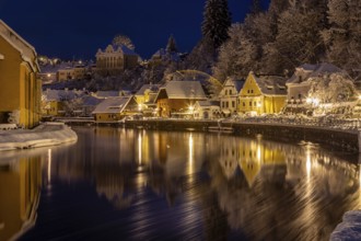 Winter view of Cesky Krumlov, picturesque houses under the castle with snow-covered roofs. Narrow