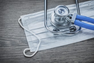 Disposable face mask stethoscope on wooden board