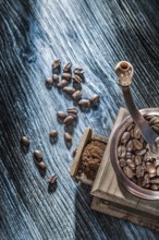 Coffee grinder beans on vintage wooden board