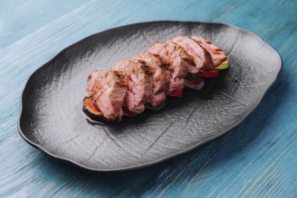 Fried pork on eggplant on black plate