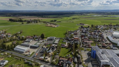 Aerial view of a village with surrounding fields and country road under a cloudy sky, Mitterteich,