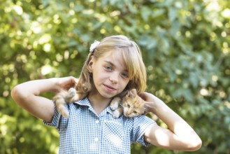 Girl play with kitten outdoor in the park