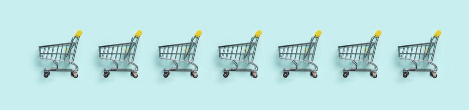 Shopping cart in row on blue background. Minimalism style. Toy trolley for supermarket. Top view or