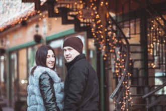 Romantic couple walking in the winter under the snow in Christmas time