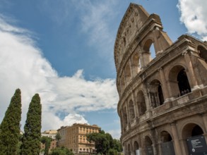 Impressive Colloseum with buildings in the background and cloudy sky, Rome, Italy