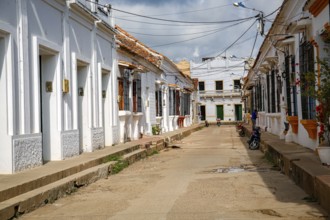 Typical street with white historic buildings in sun and shadow of Santa Cruz de Mompox, Colombia,