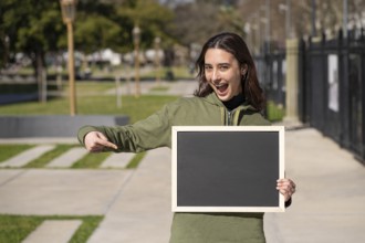 Woman holding a black poster without text. Business template concept