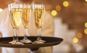 Champagne glasses on tray in bright lights. Party or celebration