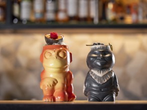 Tiki Drink Cocktails. Two tropical tiki cocktails on bar counter. Tiki cocktails on bar in night