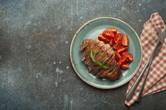 Delicious roasted sliced duck breast fillet with golden crispy skin, with pepper and rosemary, top