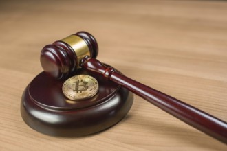 Bitcoin regulation. BTC cryptocurrency coin and judge gavel on a desk. Banned currency or law