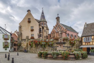 Main square with church and fountain with statue of pope Leo IX in Eguisheim, Alsace, France