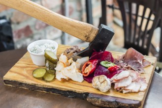 Slices fresh pork meat, lard on wooden board with vegetables, spices, stuck ax on the table