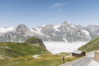 Scenic view of Alpine road through valley with sea of clouds. Grossglockner, Austria. Space for