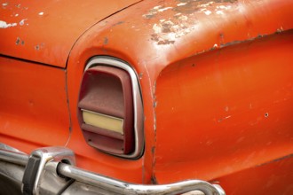 Old rusty red car with chrome bumper