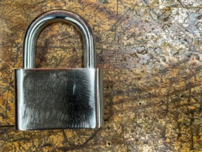 Metal padlock on a wooden background