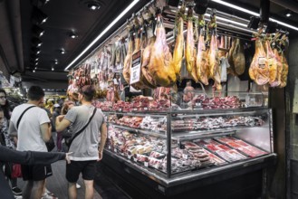 Chorizo and jamon serrano stalls at famous la boqueria market in barcelona spain