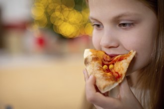 A joyful young child savoring a deliciously tasty slice of pizza, filled with pure happiness in a