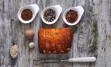 Stuffed pork belly with spices. Gammon meat with different spices on a wooden table