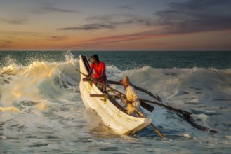 Sri Lankan fishermen breaking the wave at Kahandamodara Beach, Sri Lanka