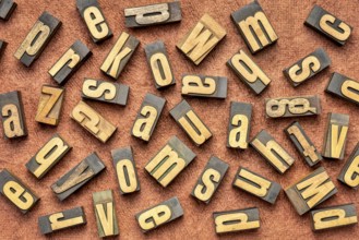 Random letters overhead background - vintage letterpress wood type (inverted image) against brown