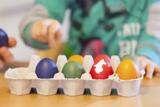 Mother and child painting eggs for Easter holidays