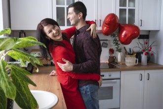 Man and woman in love date at home in kitchen happy hugs. Valentine's Day, happy couple, love story