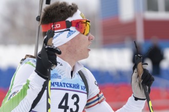 Portrait Russian sportsman biathlete Zlobin Vladislav Khanty-Mansiysk at finish after rifle