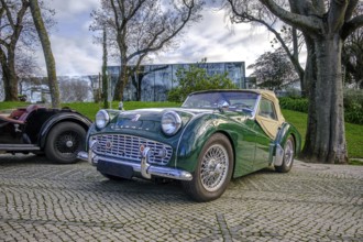 Lisbon, Portugal, Jan 20, 2024: A classic green Triumph TR3A soft top drophead car cobblestone