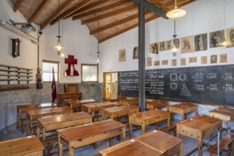 Classroom around 1900 with wooden desks and slate board with maths problems in the school for the