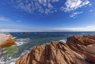 Coastal landscape with red rocks and surf in blue sky and sunshine, Spiaggia di Cala E'Luas,