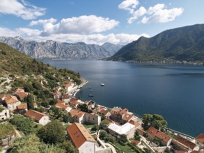 View of the Bay of Kotor over the red roofs of old houses. Perast, Montenegro. Drone.